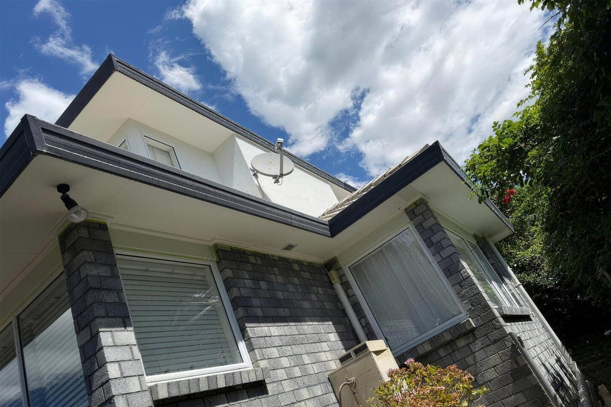 Freshly painted white weatherboard home with dark trim, finished by EGP Decorator Limited